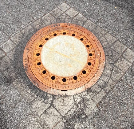 Schachtabdeckung in Pflaster